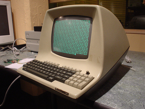 An image showing a terminal and a computer in the early days of computing.