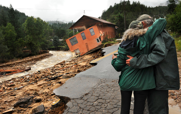 An emotional couple looks on at a home destroyed by the floods near Jamestown, Colorado.